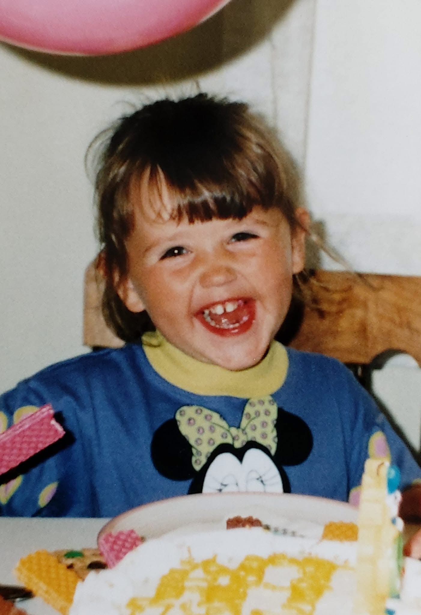 Childhood birthday photograph in a Minnie Mouse shirt